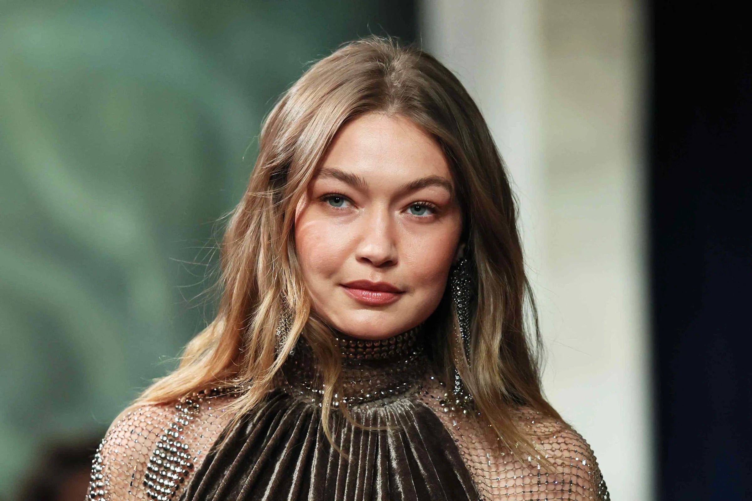 Gigi Hadid in a teal string bikini top and neon green jacket for Guest in Residence Spring 2026