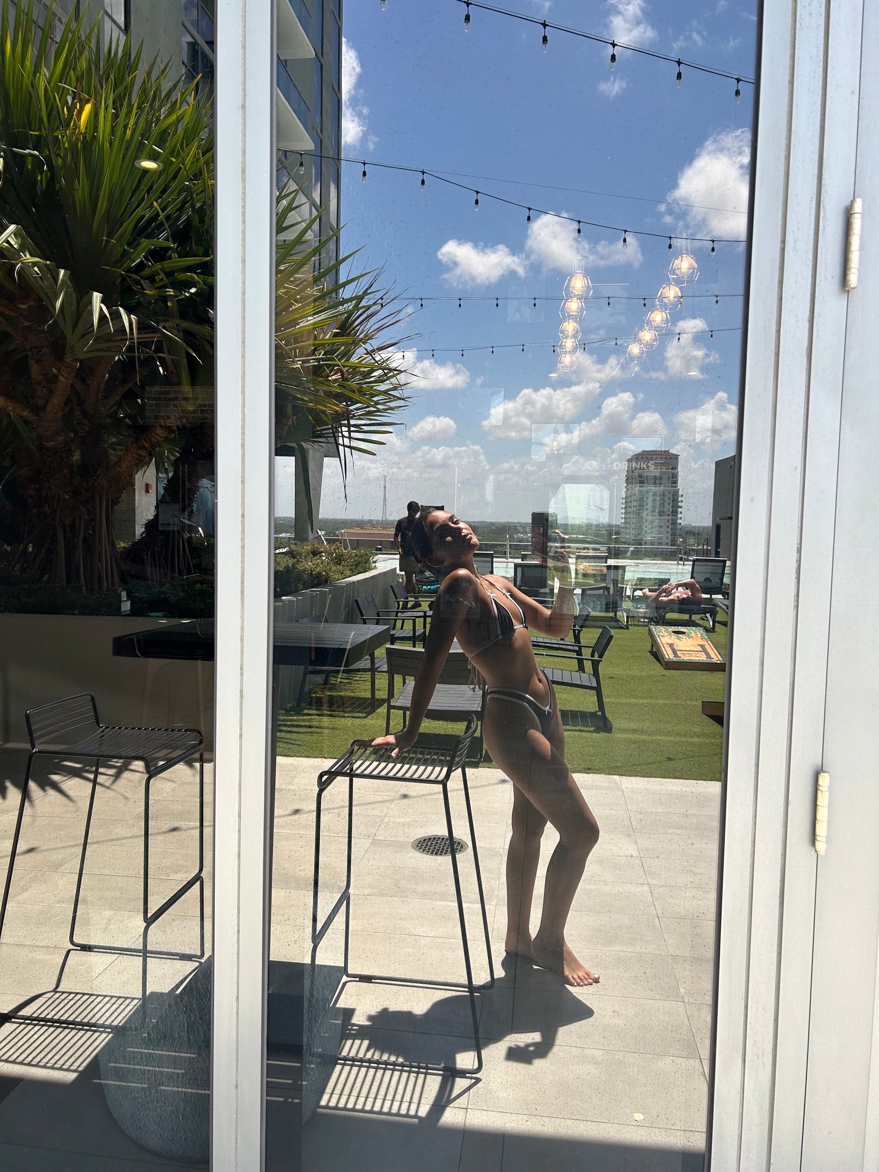 Woman in Audi Swim luxury thong bikini on resort pool deck — Turks and Caicos spring break 2026 style